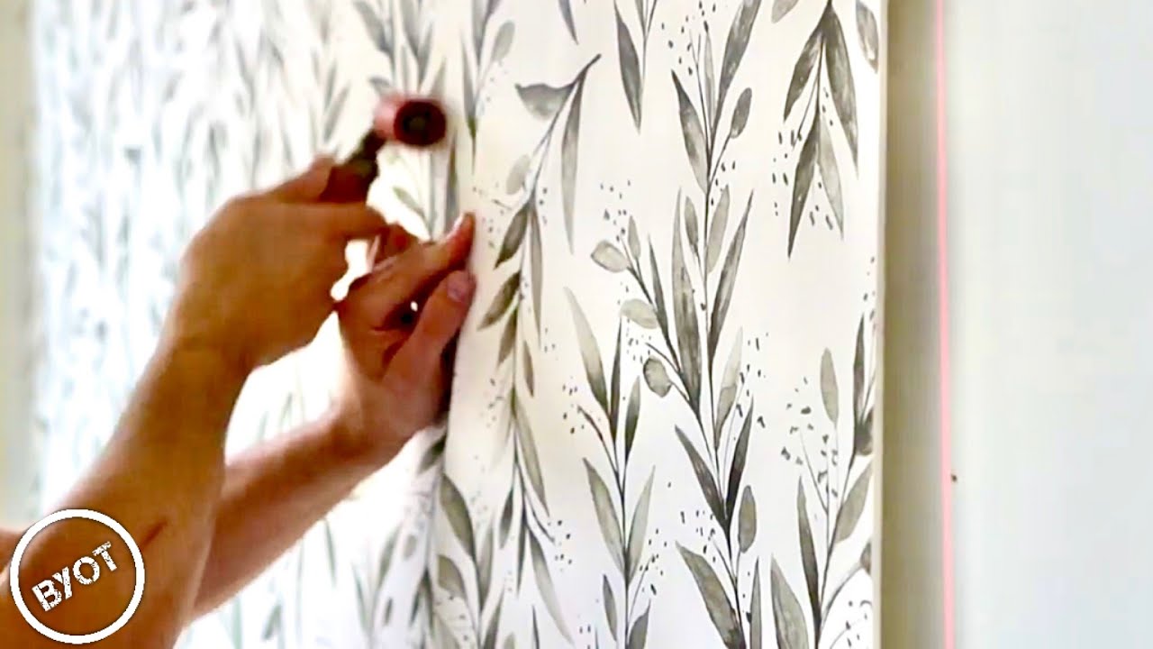 Wallpaper installer smoothing wallcovering during a careful installation